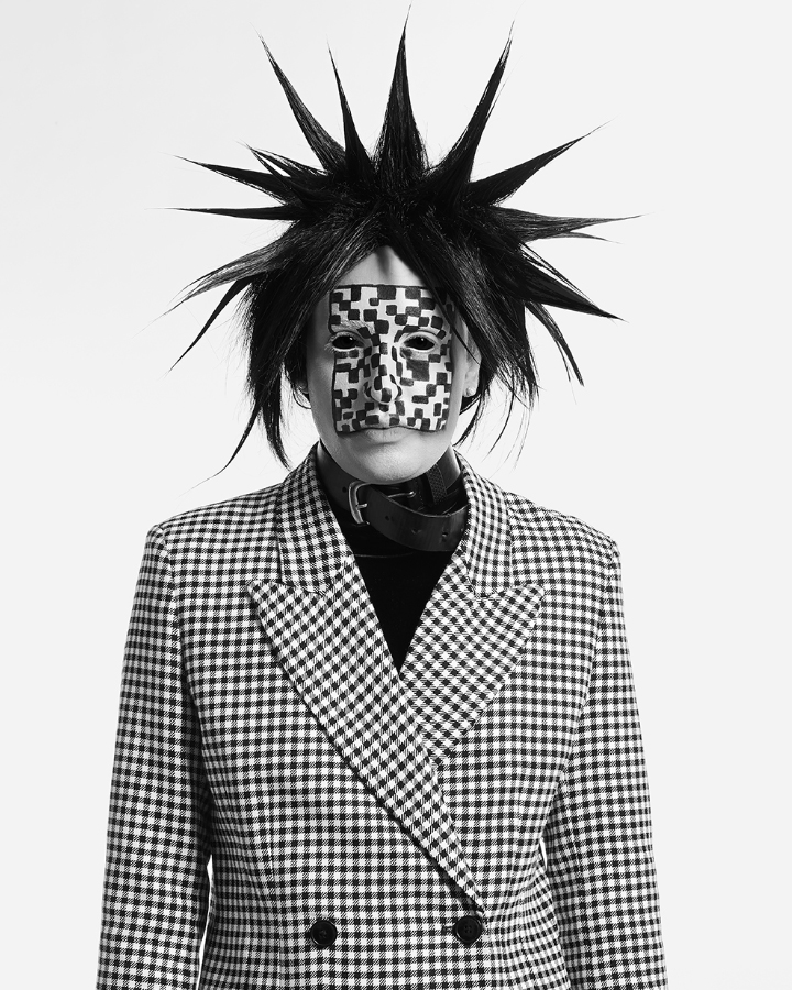 Jesse Clark posing with checkered black and white facepaint against a white background.
